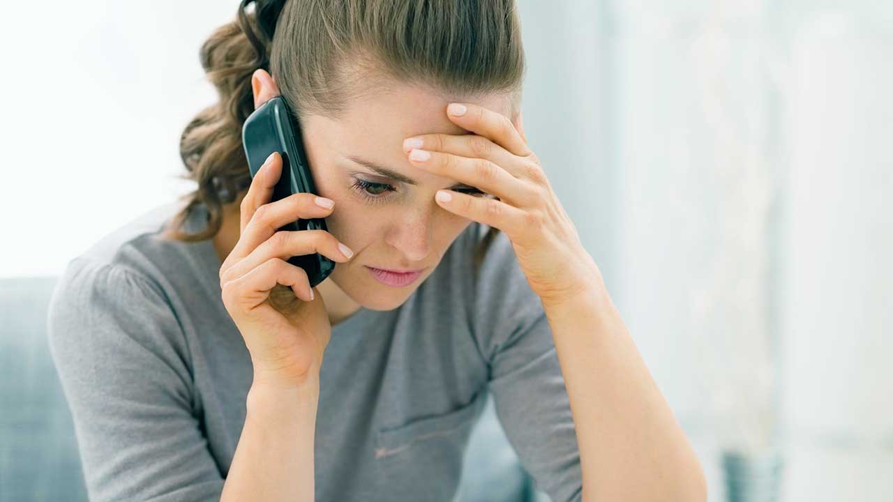 Frau niedergeschlagen am Telefon