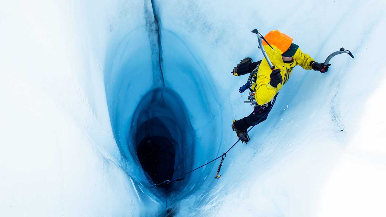 Eiskletterer in Alaska kletter aus einem Loch in einem Gletscher